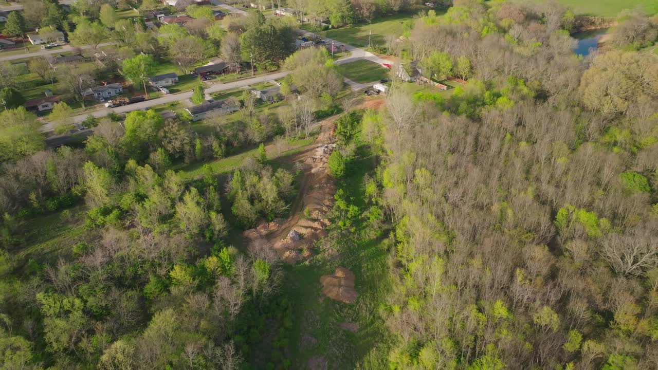 aerial volando por encima de las cimas de los árboles en fayetteville, el muñeco revela el depósito de chatarra