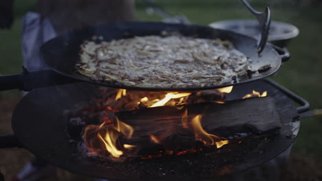cooking outdoors on a grill over a campfire