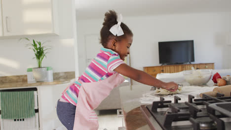 Feliz-Niña-Afroamericana-Rodando-Masa-En-La-Cocina