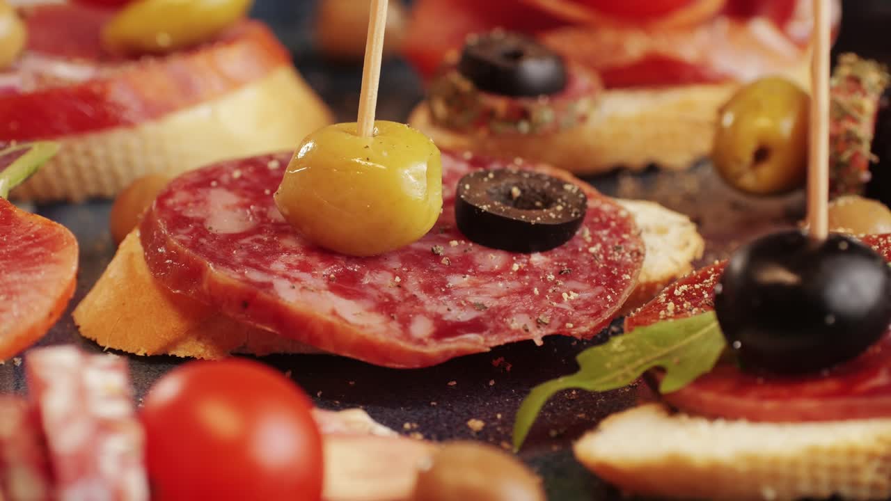 Mix of spanish pork sausages, Cutting board of appetizing catalonian snack - fuet, jamon, chorizo, olives, supermarket tapas food in spain, traditional cuisine.