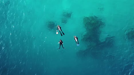 aerial shot of three scuba divers floating in the ocean, solomon islands