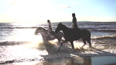 caballos montando en el océano al atardecer