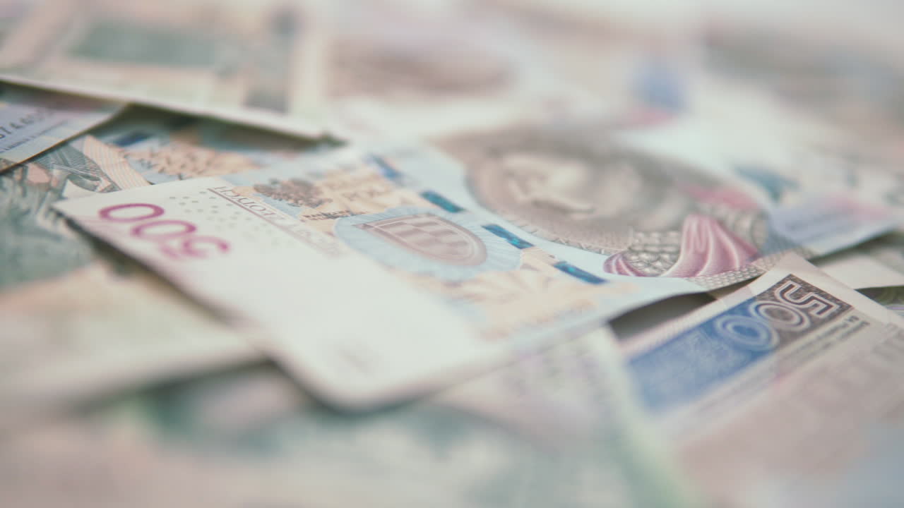 Fokus: pada uang kertas zloty Polandia 500 dengan latar belakang uang lainnya.