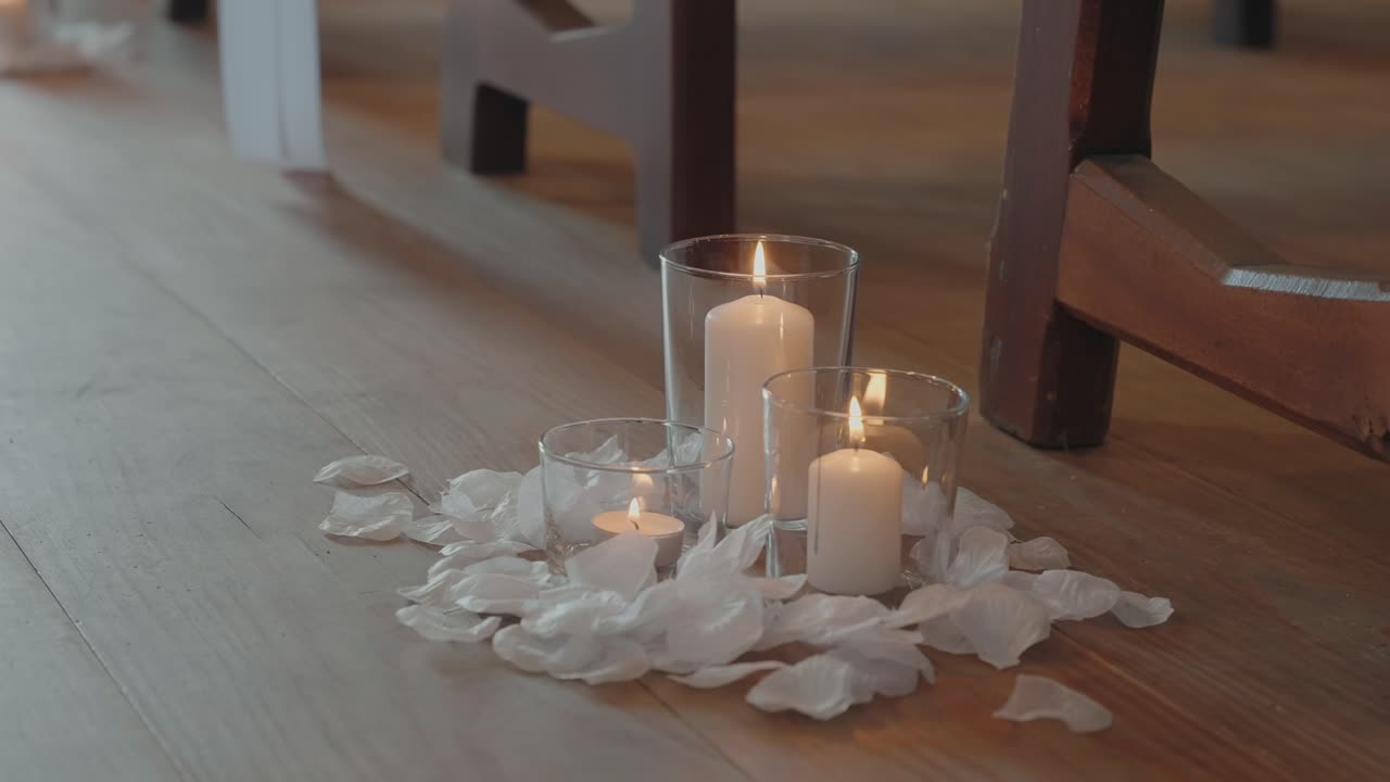 Soft glowing candles surrounded by white petals creating an intimate romantic mood