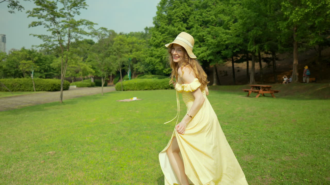 siguiendo a la niña corriendo por el césped verde girar a mitad de vuelta a través del parque en cámara lenta