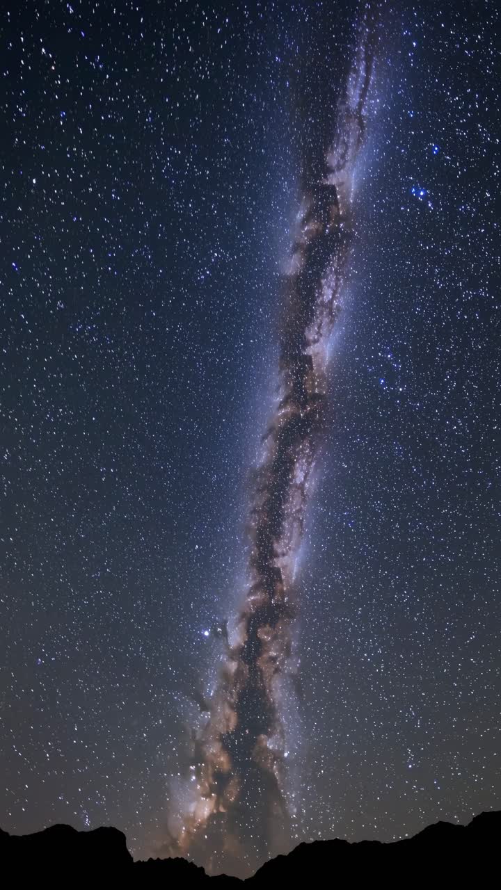 A vertical video captures the Milky Way galaxy in a stunning night sky, shot from a low angle