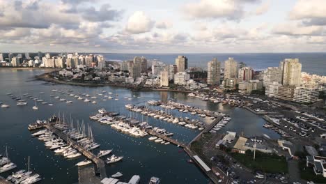 Luftaufnahme-Des-Stadtbildes-Von-Punta-Del-Este-In-Uruguay.-Drohne-Fliegt-über-Den-Hafen,-Während-Ein-Segelboot-In-Der-Bucht-Festgemacht-Ist