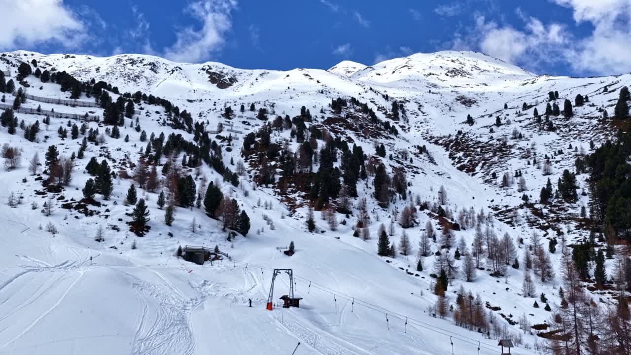 Carrellata aerea sopra la funivia e le montagne innevate a Skigebiet Schöneben, Austria, paesaggio alpino invernale