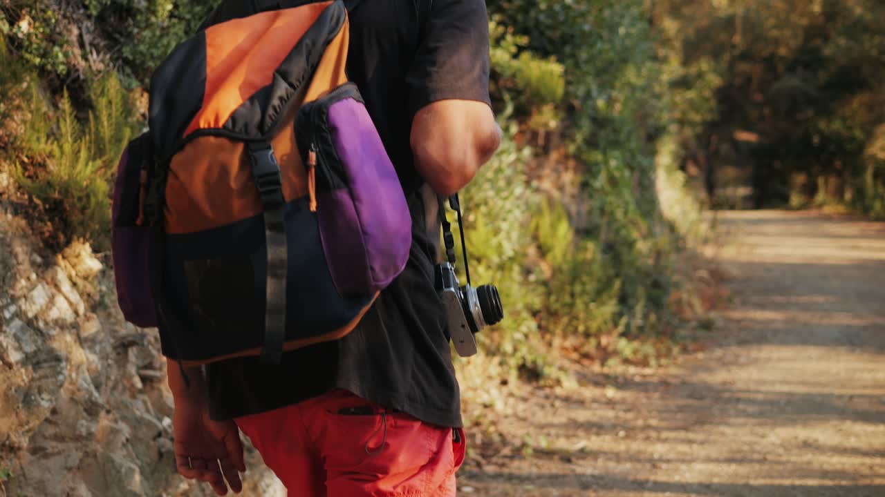 Man Hiking with Backpack and Camera in a Forest