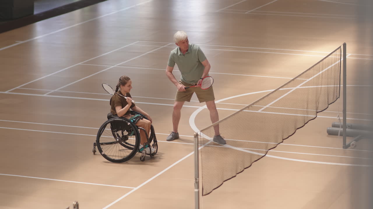 Coach Demonstrating Moves with Badminton Racket