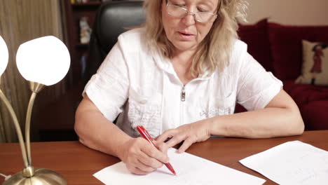 mujer de mediana edad escribiendo en la mesa