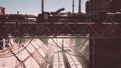 un paisaje urbano futurista e industrial con estructuras de acero oxidado y un patrón de cuadrícula.