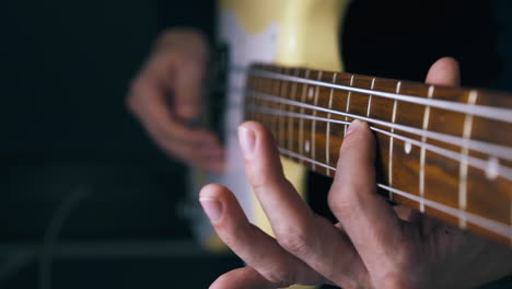 teacher performs pitch shift technique on white bass guitar