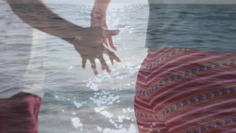 Animation-of-lights-over-hands-of-african-american-couple-walking-on-beach