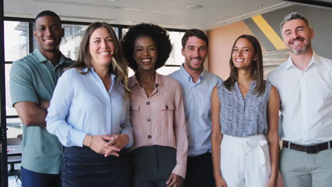 Portrait-Of-Smiling-Multi-Cultural-Business-Team-Standing-In-Modern-Office