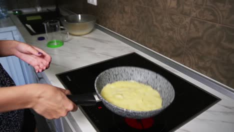 Female-hands-spreading-pancake-Mixed-in-a-frying-pan.-Homemade-food.-Slow-Motion-shot