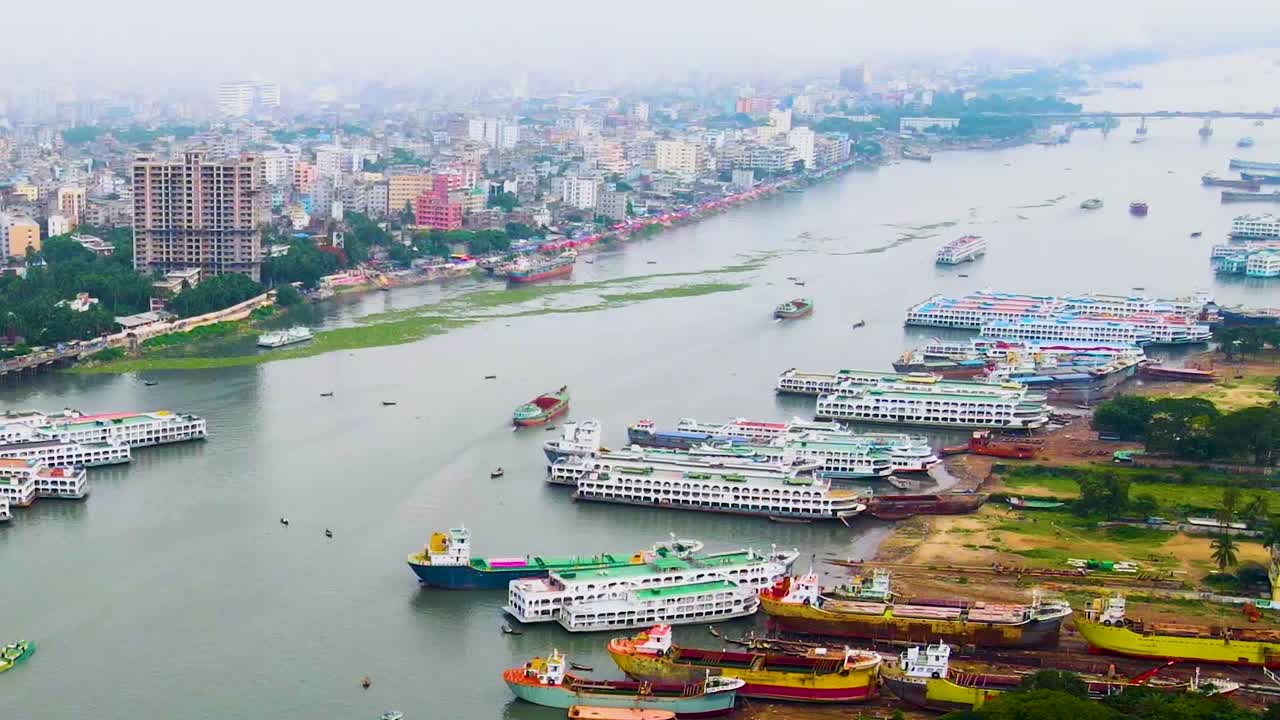 Porto fluvial com navios e barcos ao longo do rio Buriganga em Daca, Bangladesh - Tomada aérea de drone.