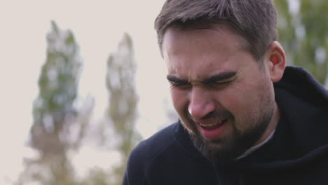 uomo stanco che respira pesantemente al parco al mattino