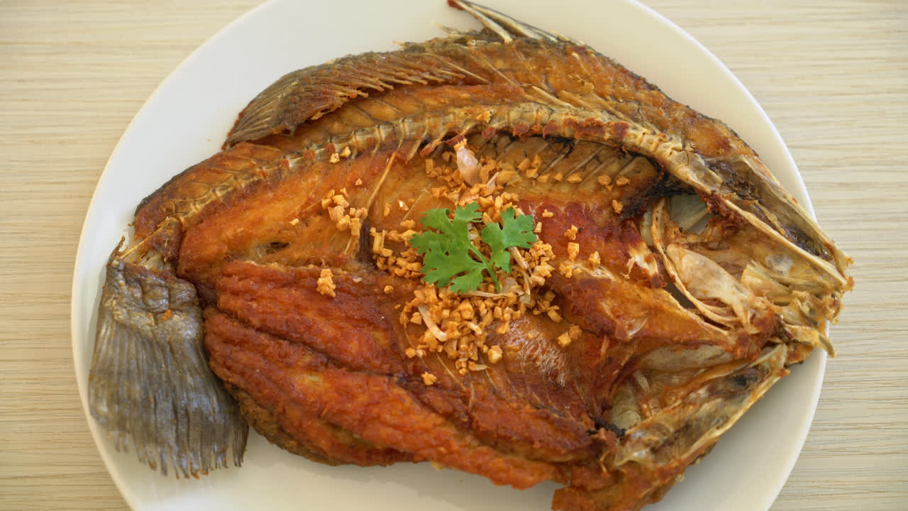 lubina frita con ajo en el plato