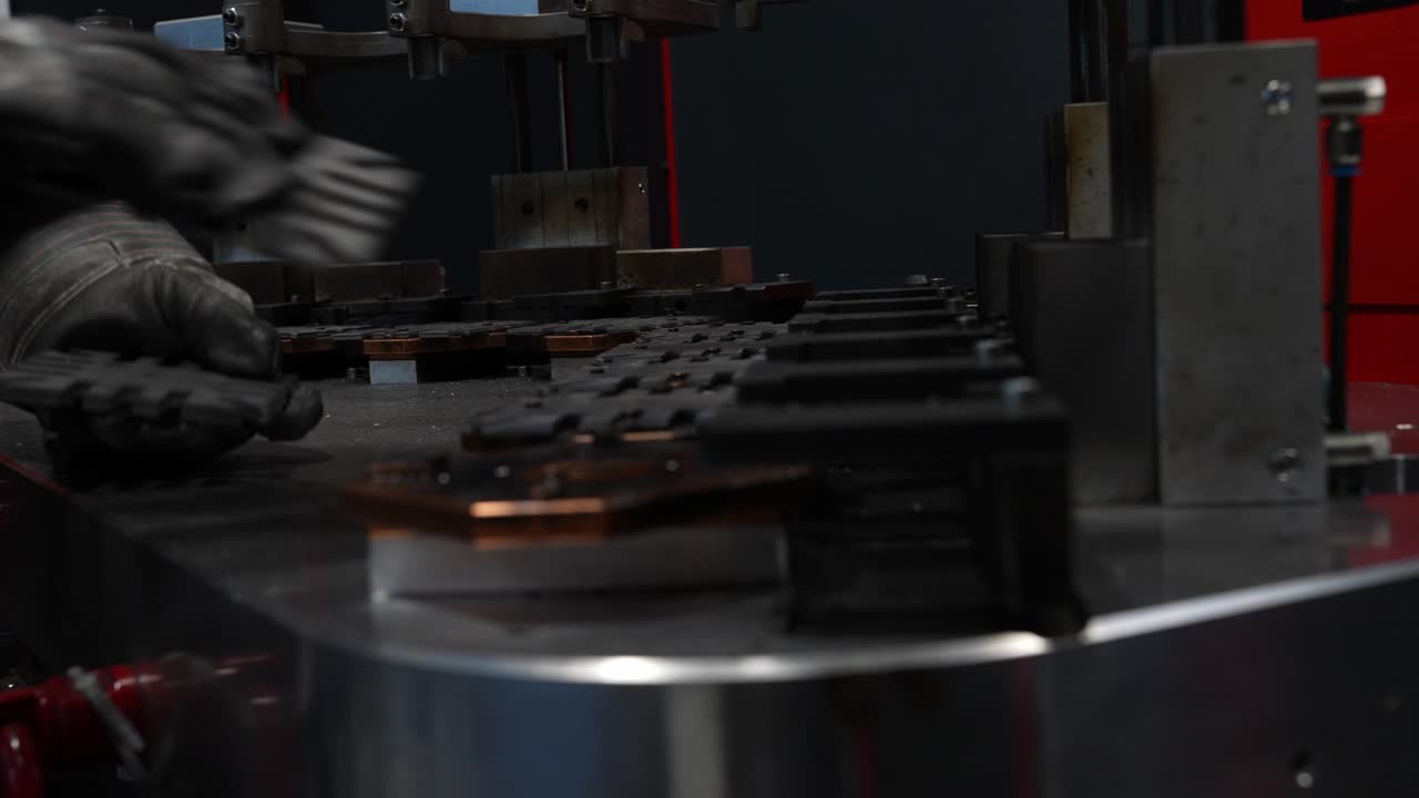 Manual placement of metal washers into a fixture during manufacturing setup, showing accurate positioning, repeatable handling and careful preparation for a precise industrial production process