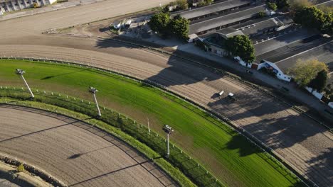 aerial tilt up shot of tractor preparing race course for horse event in summer in buenos aires