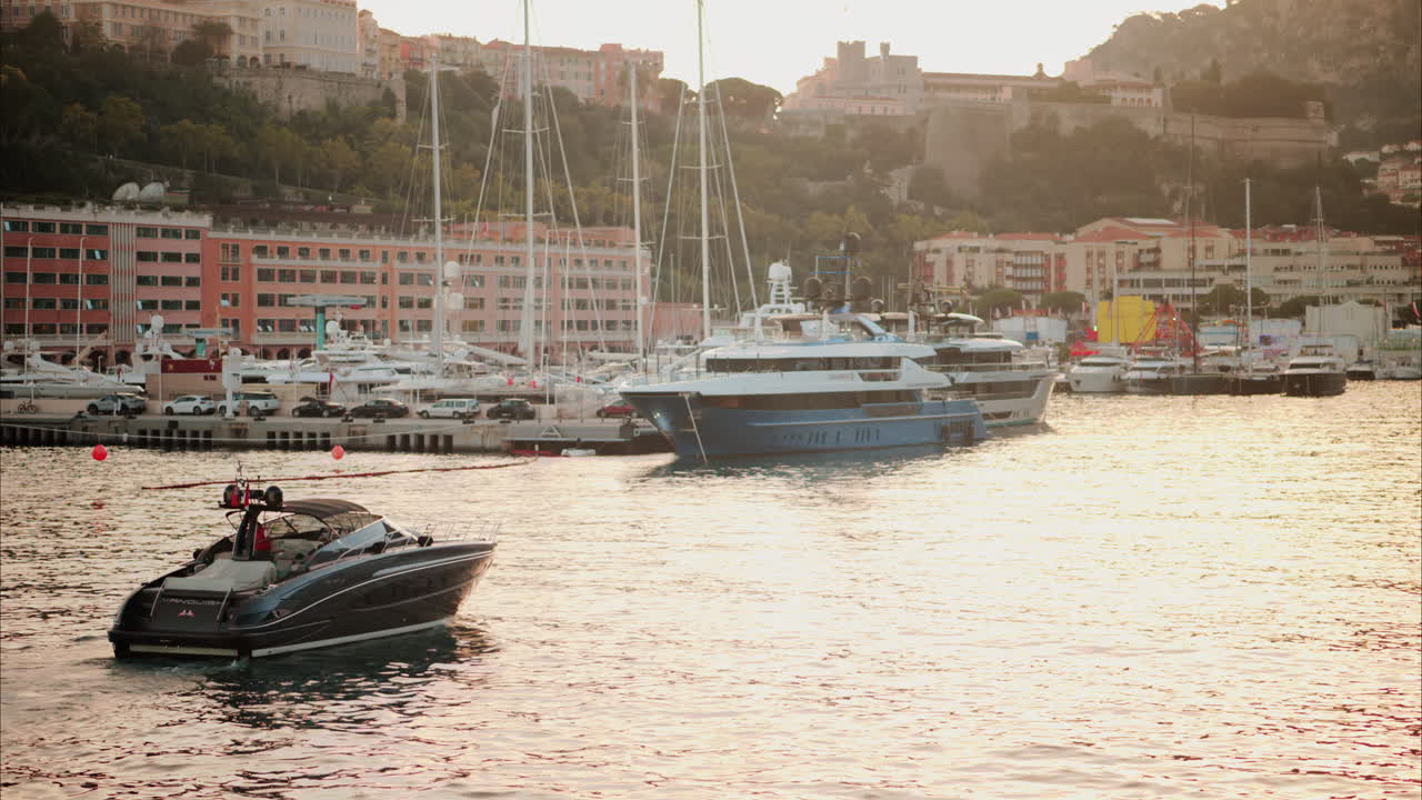 La Condamine, Monaco - October 4, 2024: Boats moving through the Monaco Marina with the skyline of the city on the background