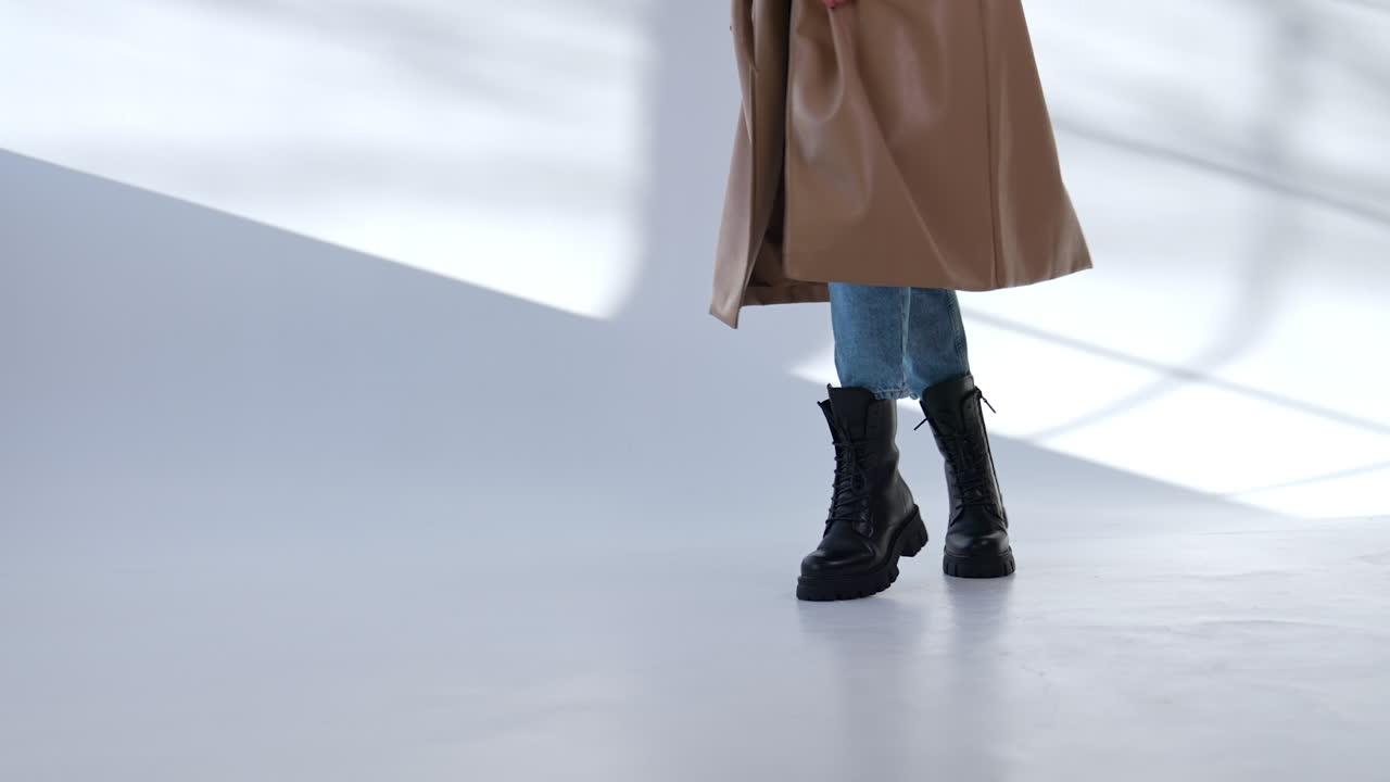 Woman Walking in a Beige Coat and Black Boots