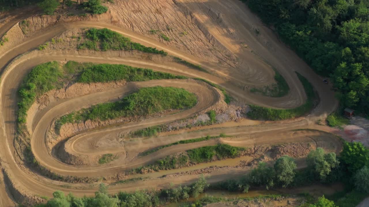 Serpentine motocross course weaving between hills and trees in rural Slovenia