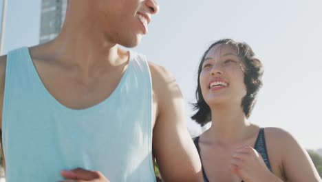 Happy-biracial-couple-running-on-promenade,-in-slow-motion