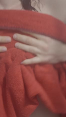 close-up of a person's torso partially covered by a red cloth