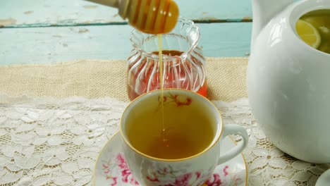 hand pouring honey in herbal tea 4k