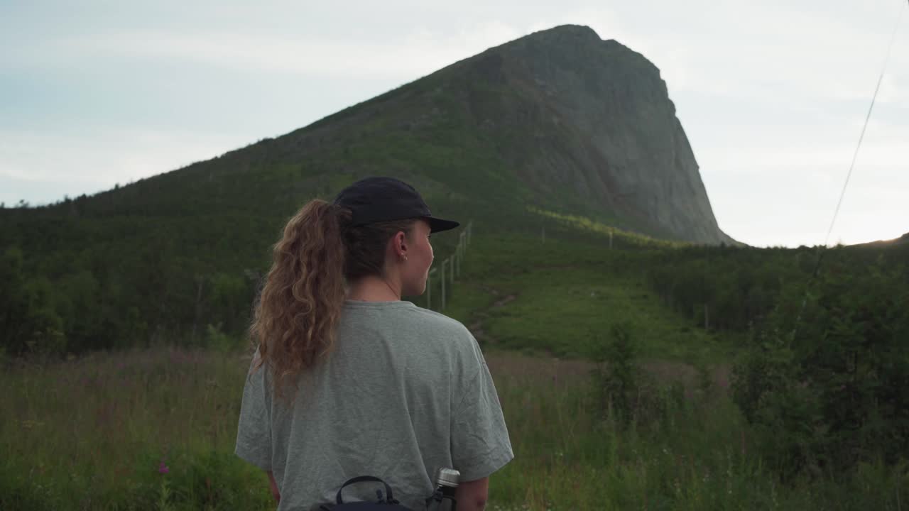 parte trasera de una mujer excursionista en los senderos de la montaña hesten en las islas senja, noruega