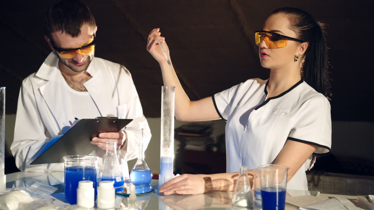 Two scientists work in the laboratory. Testing of chemicals. Scientific discoveries.