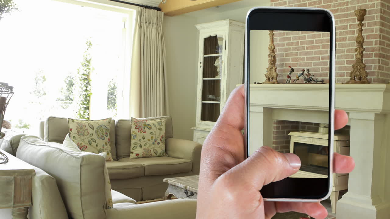 persona que sostiene un teléfono inteligente con interiores modernos de la sala de estar mostrados en la pantalla