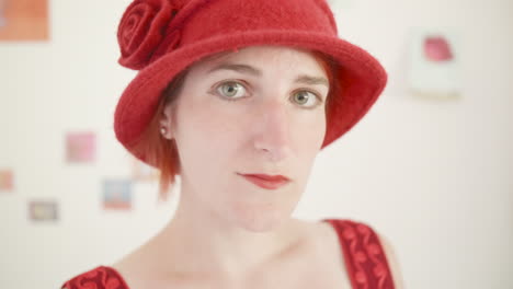 golden twenties - red haired girl adjusting her hat and coquetting with the camera