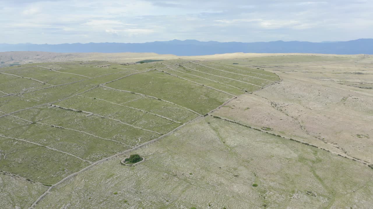 크로아티아 의 크르크 섬 에 있는 언덕 이 있는 농지 의 넓은 앞쪽 공중 사진