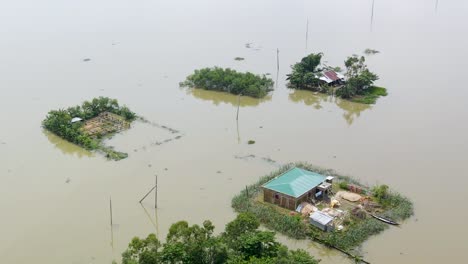 rural village homes submerged in flood water in bangladesh. aerial drone shot