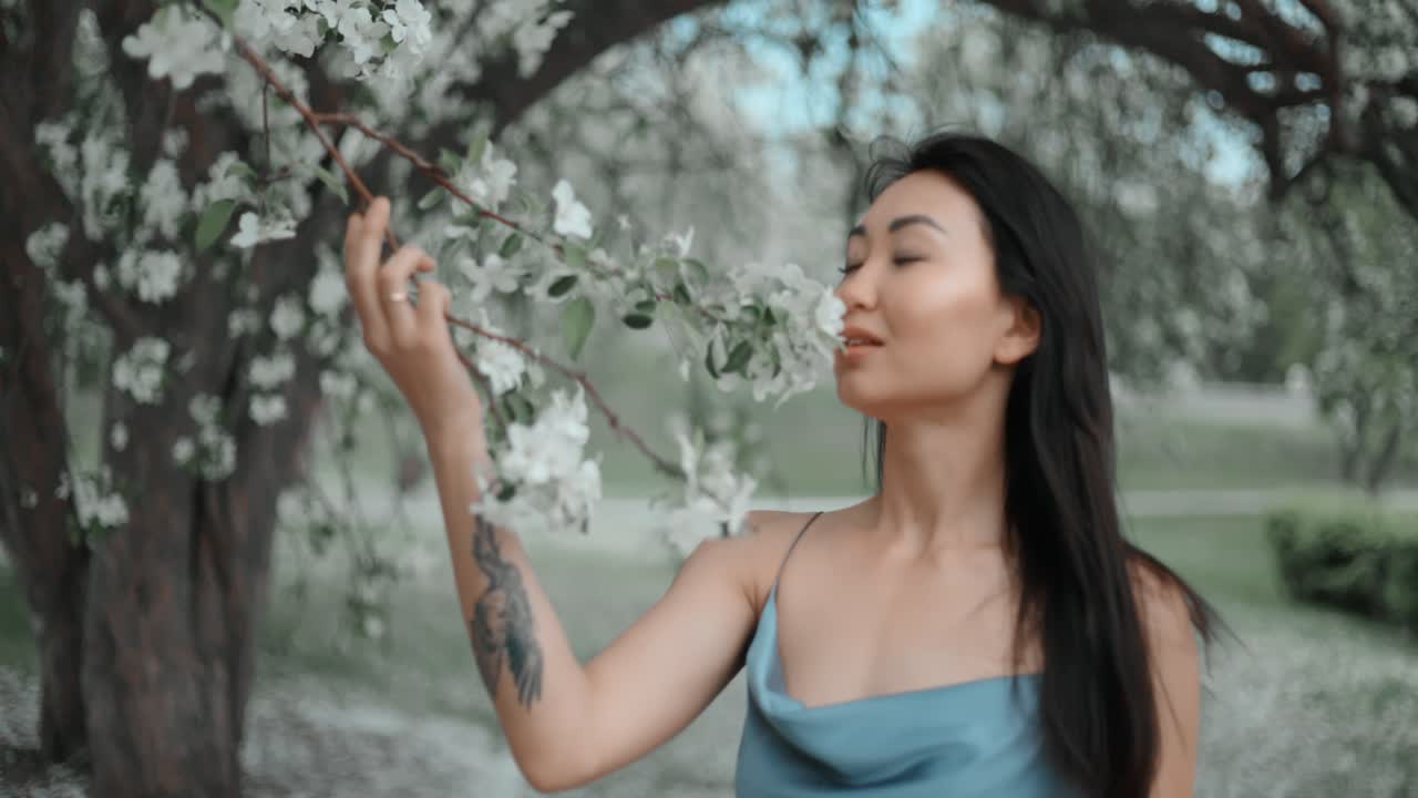 Woman enjoying apple blossoms in a spring park