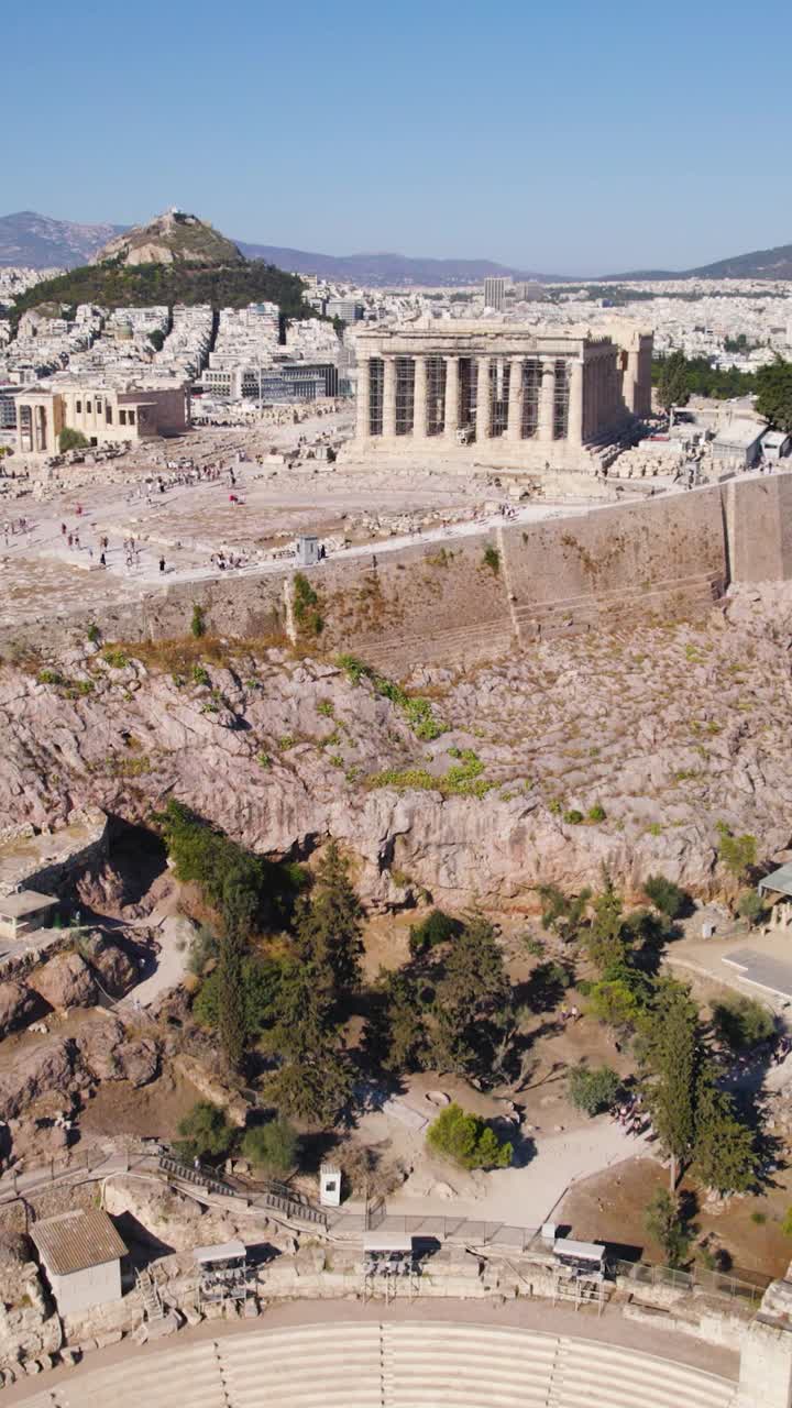 Aerial vertical shot showing Athens’ Parthenon and the Odeon of Herodes Atticus, showcasing the historic architecture and hilltop layout