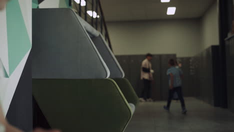 Cute-focused-girl-sitting-bench-in-school-hallway-close-up.-Education-concept.