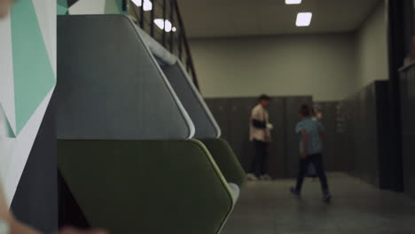 Cute focused girl sitting bench in school hallway close up. Education concept.