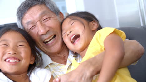 Slow-Motion-Shot-Of-Grandfather-And-Granddaughters-Laughing