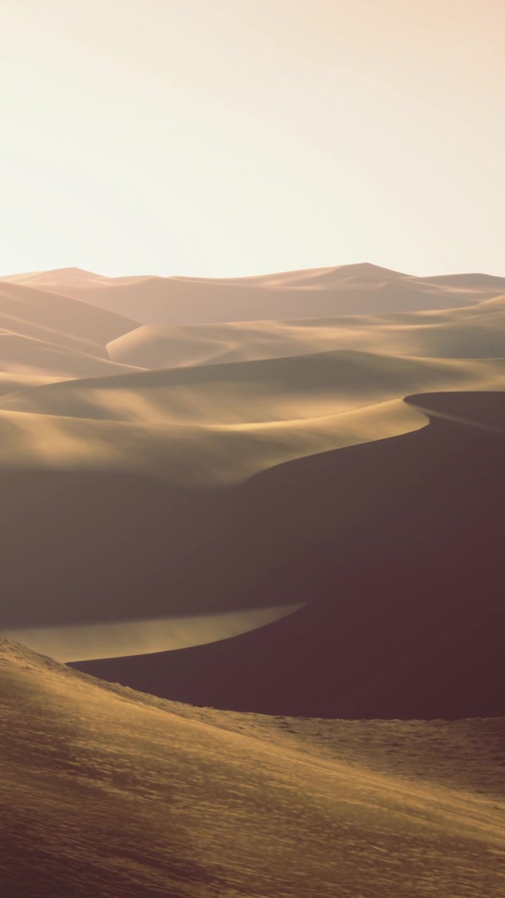 Dune di sabbia si estendono nel paesaggio sotto la calda luce del sole in un deserto.
