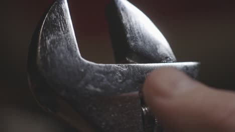 turning the worm screw of the wrench with one finger adjusting the gap between the two jaws - closeup shot