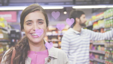 animación de iconos de corazones cayendo sobre una pareja caucásica en la tienda