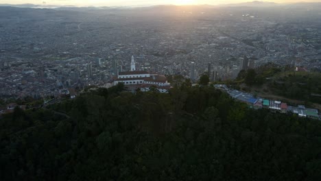 cerro de monserrate in bogotá iconic church, overlooking the city from a scenic mountain top, pullback at sunset golden hour