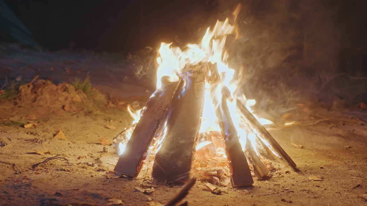 Campistas comparten risas alrededor de una fogata encendida. Noche animada con amigos reunidos alrededor del cálido resplandor de la hoguera. Alegre grupo de campistas intercambian historias y asan malvaviscos bajo cielos estrellados.