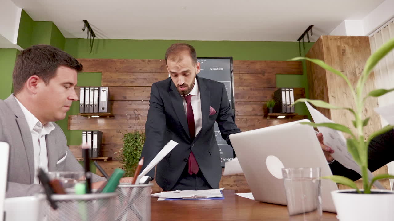 Man in business suit giving his colleagues statistics