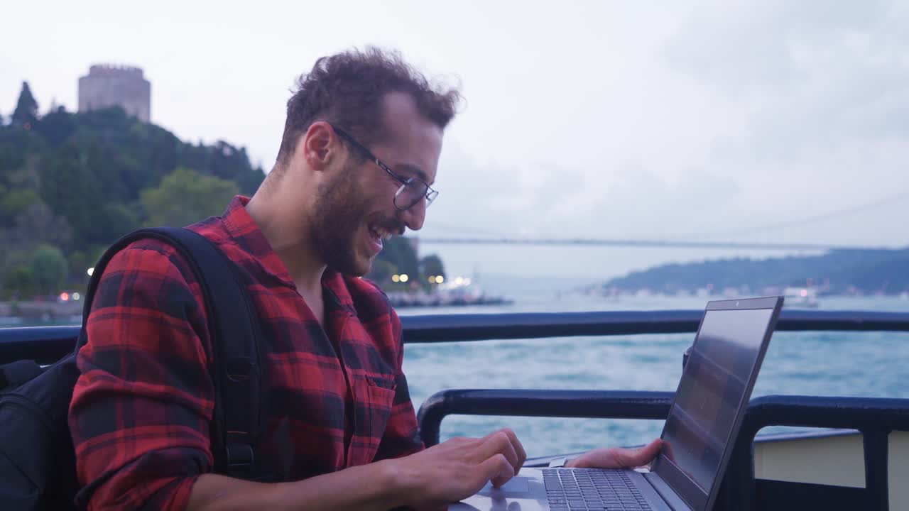 o homem que está feliz com o seu sucesso no portátil.