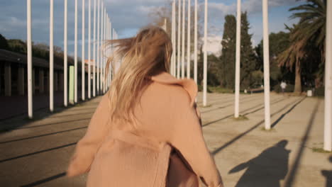 une jeune femme élégante qui court à l'extérieur.